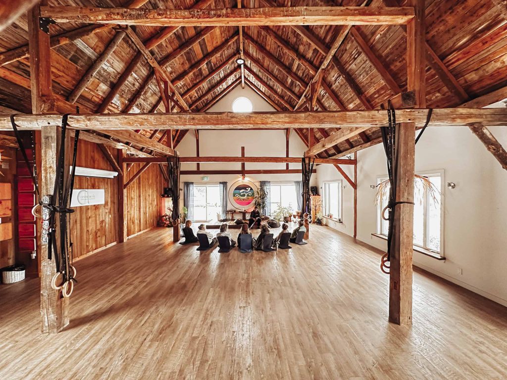 Grande salle aux poutres de bois préparée pour une méditation de groupe