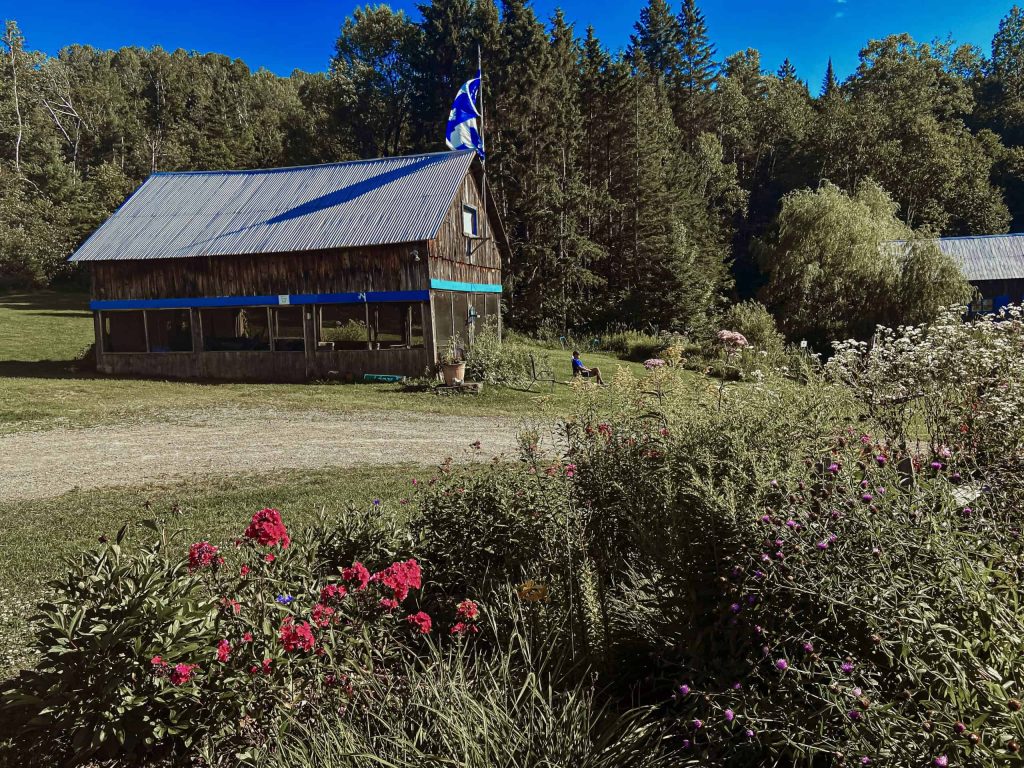 Grange en bois du domaine entourée de fleurs