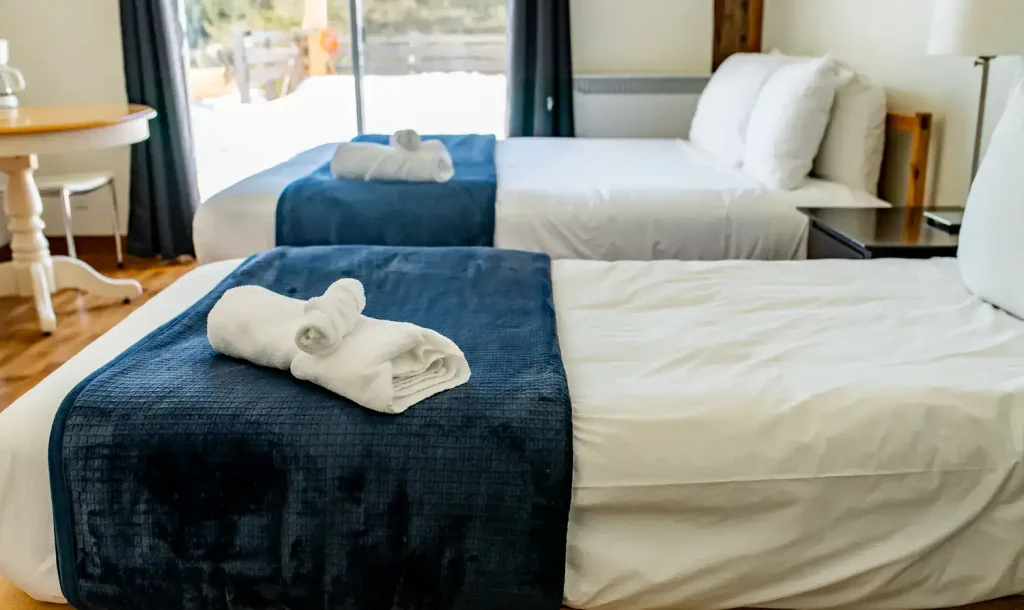 Chambre avec lits simples et literie bleue au Centre de vie