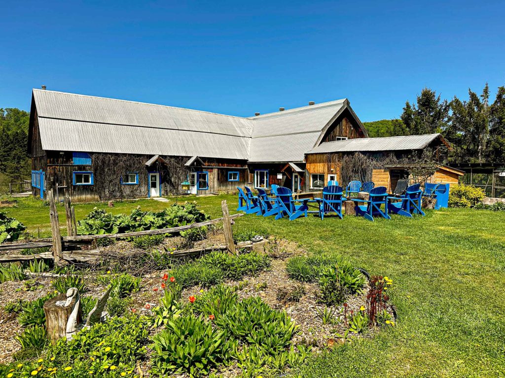 Grange et chaises Adirondack bleues au milieu des jardins