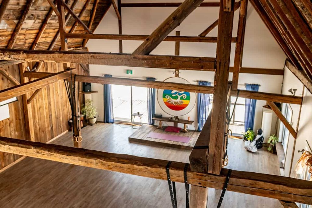 Salle de yoga aux poutres de bois apparentes