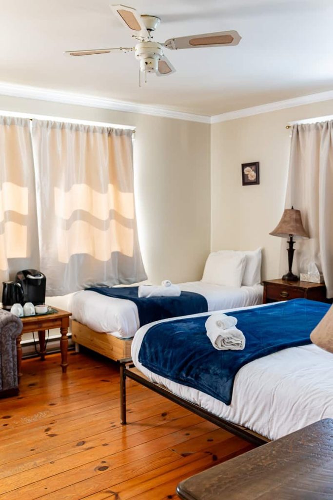 Chambre lumineuse avec lits simples et literie bleue