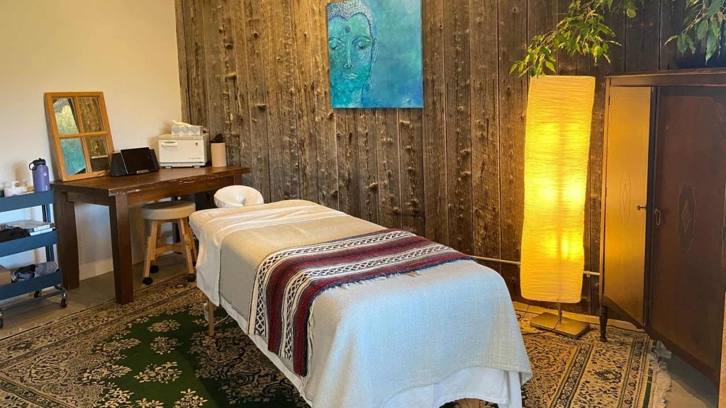 Salle de massothérapie avec table de massage et lumière douce