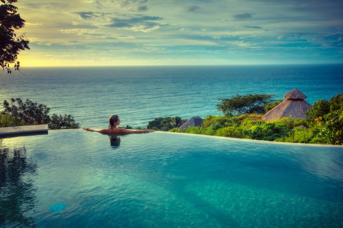 Participante dans la piscine à débordement du Haramara Retreat, vue sur l’océan